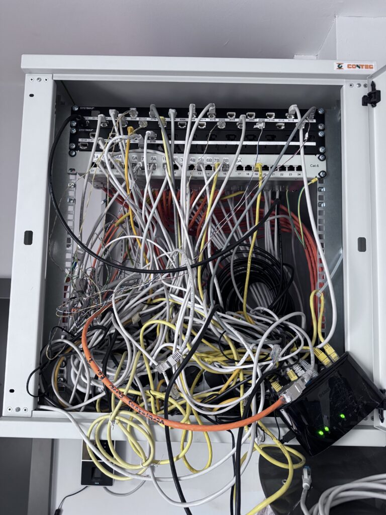 Netzwerkschrank in einem Orthopädiezentrum in Wien vor der Neuordnung